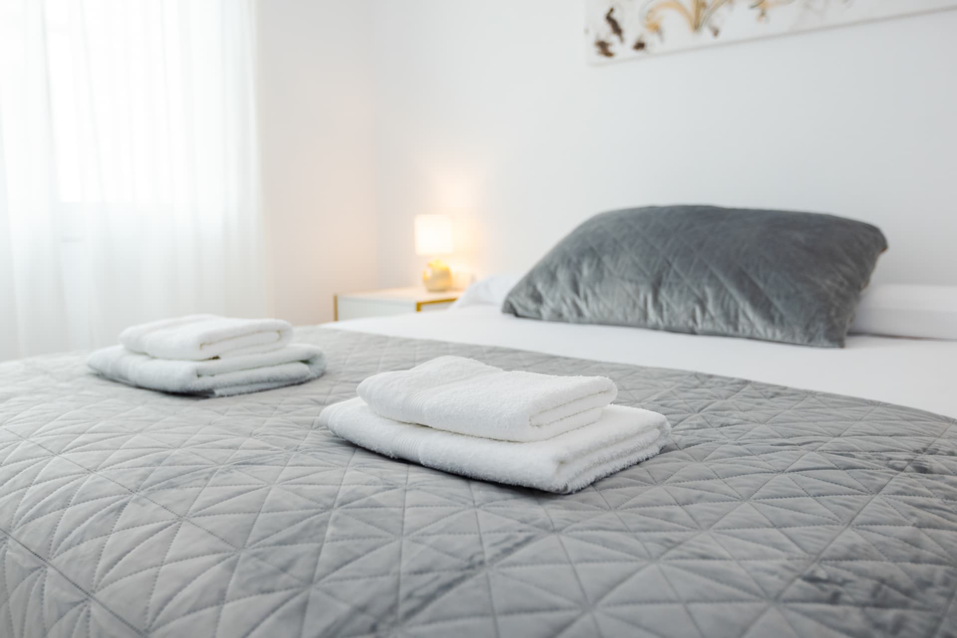 Slaapkamer met opgemaakt bed en handdoeken